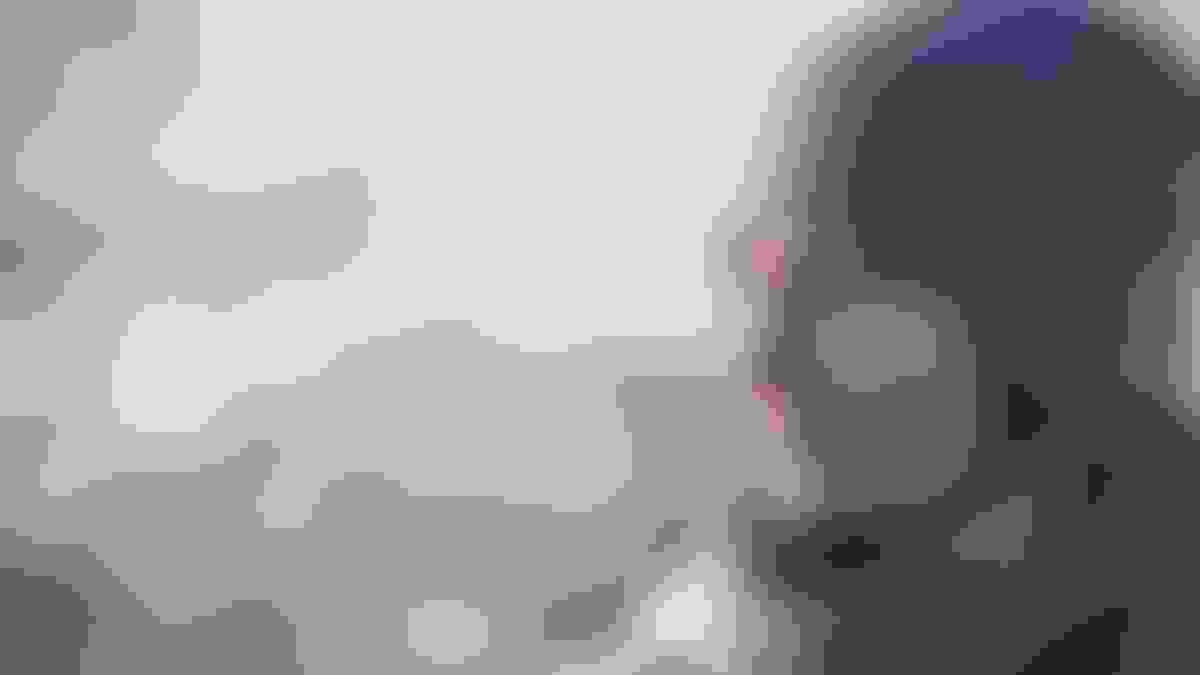 Close up of a woman in a cap and scarf who has had surgery of the upper aero-digestive tract
