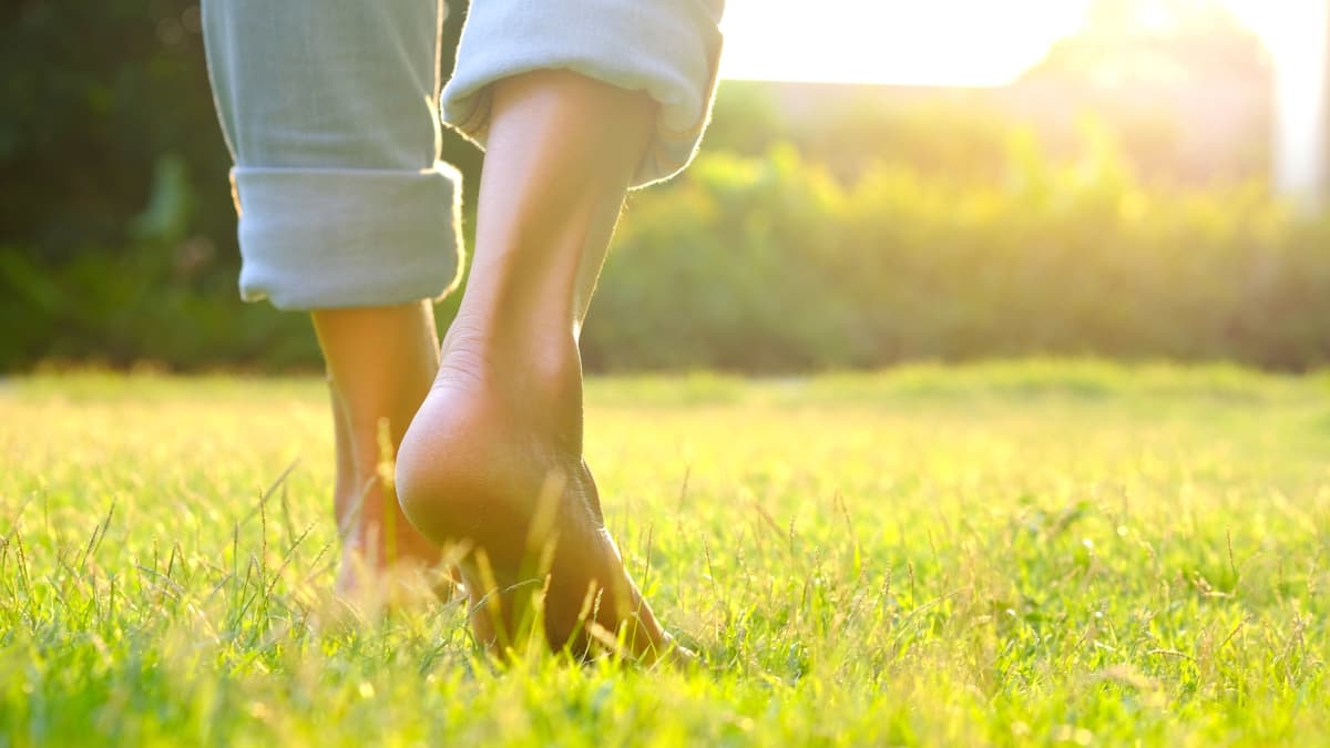 woman walking in grass after recovering from COVID-19