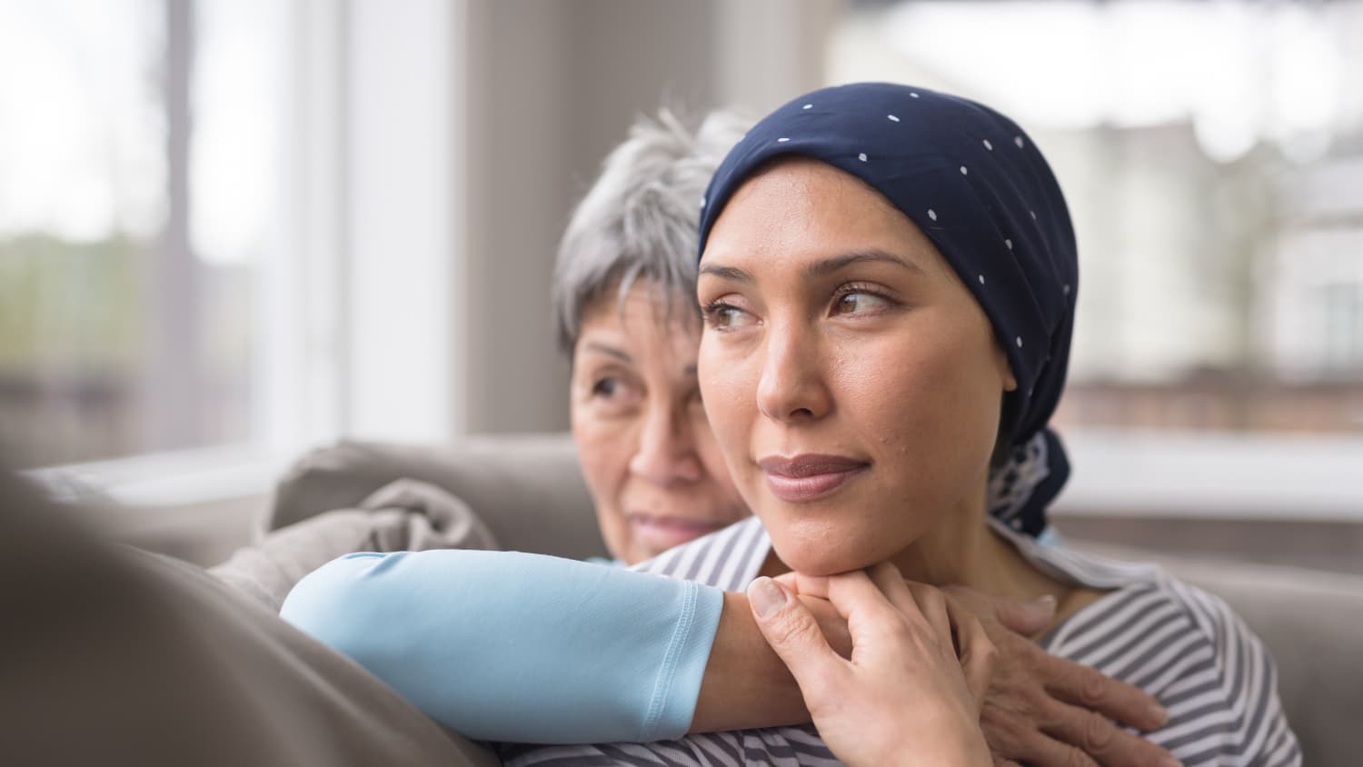 older woman holding younger woman, who has breast cancer