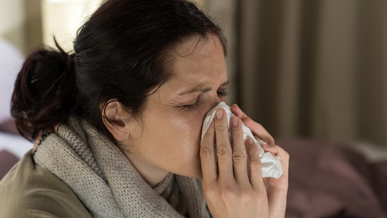 young-sick-woman-sneezing-in-tissue-sweating-from-flu-fever-SBI-300904846