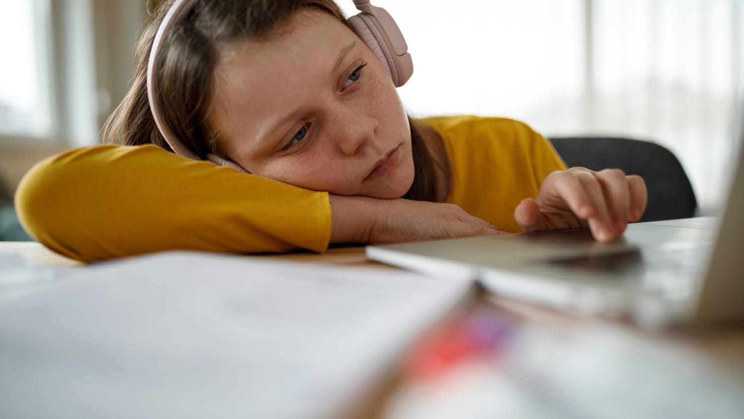 girl with head resting on her books, possibly from long COVID