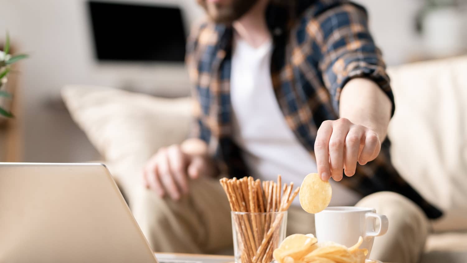 Man snacking, possibly in response to anxiety related to the COVID-19 pandemic