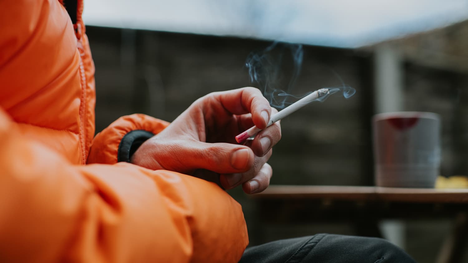 man holding cigarette representing dangers of thirdhand smoke