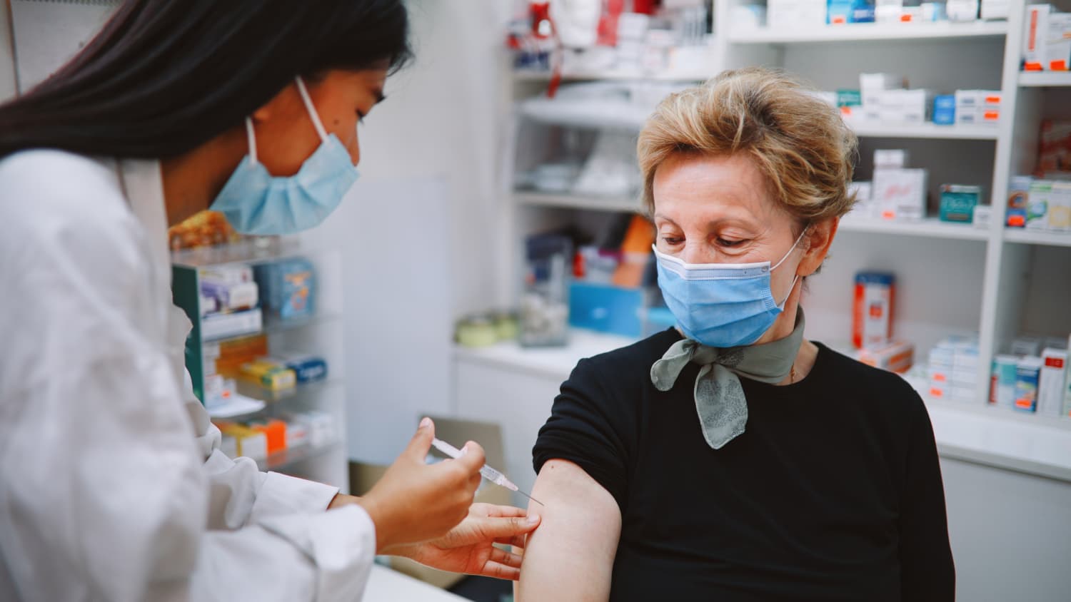 nurse giving a vaccine to an elderly patient