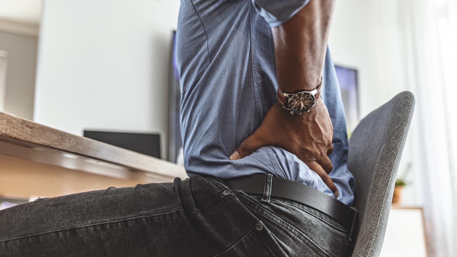 Man with pain from kidney stones, touching his lower back