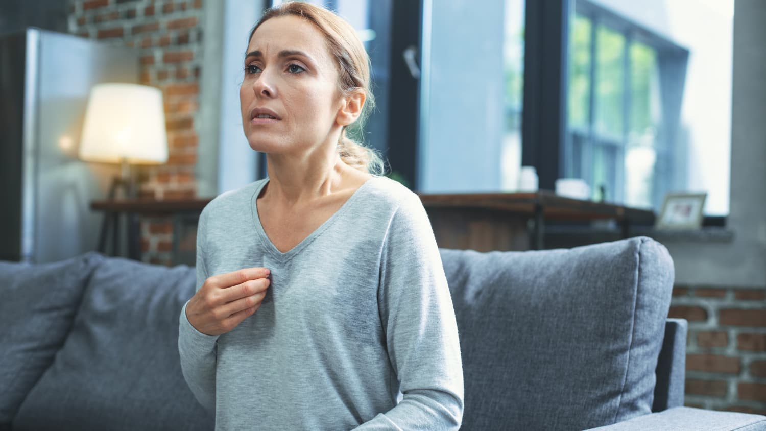woman on couch experiencing a hot flash