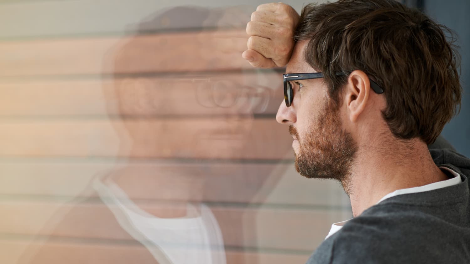 A man with meningiomas stares out of a window.