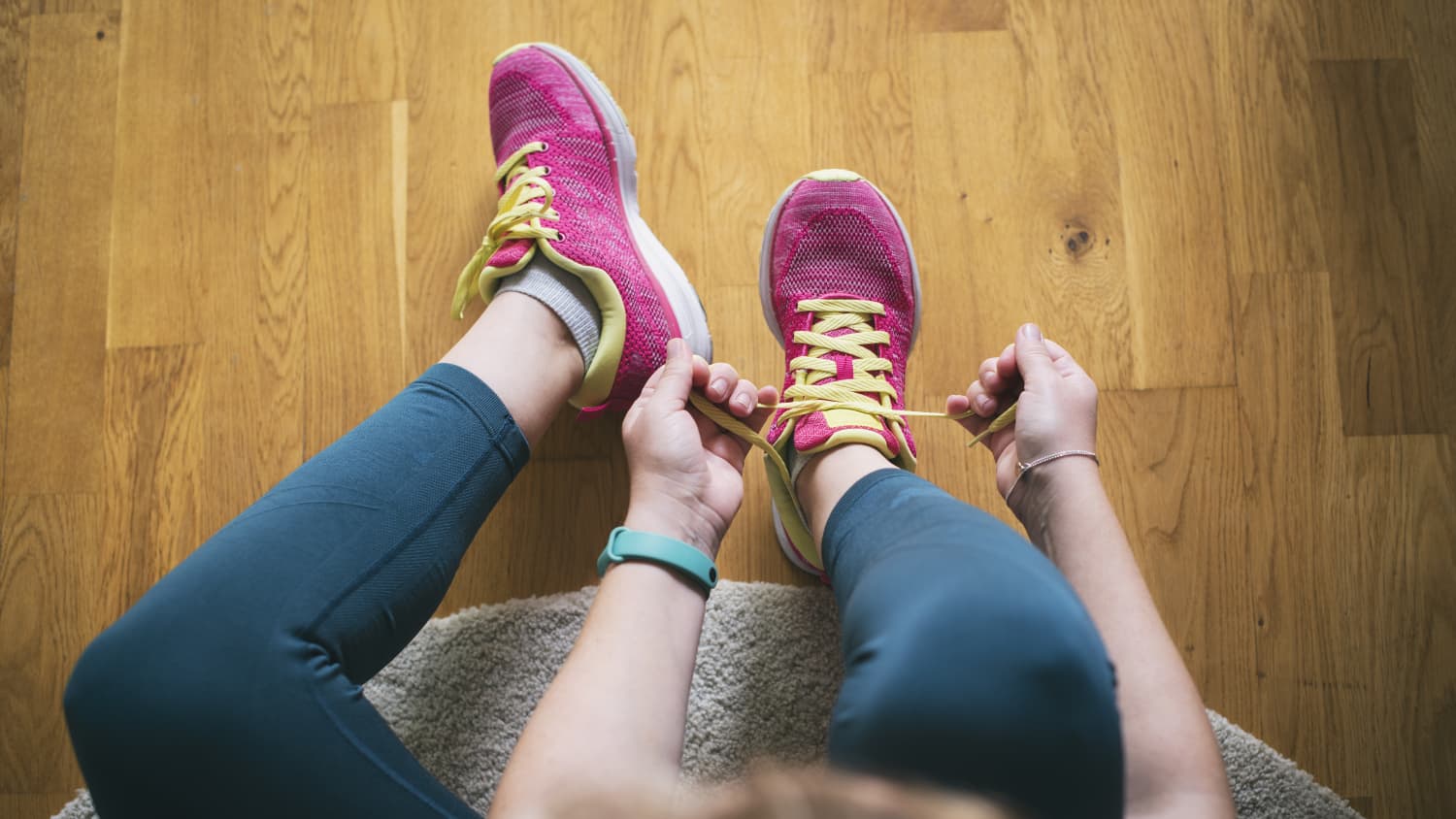 woman lacing up for a run before doing mobility exercises
