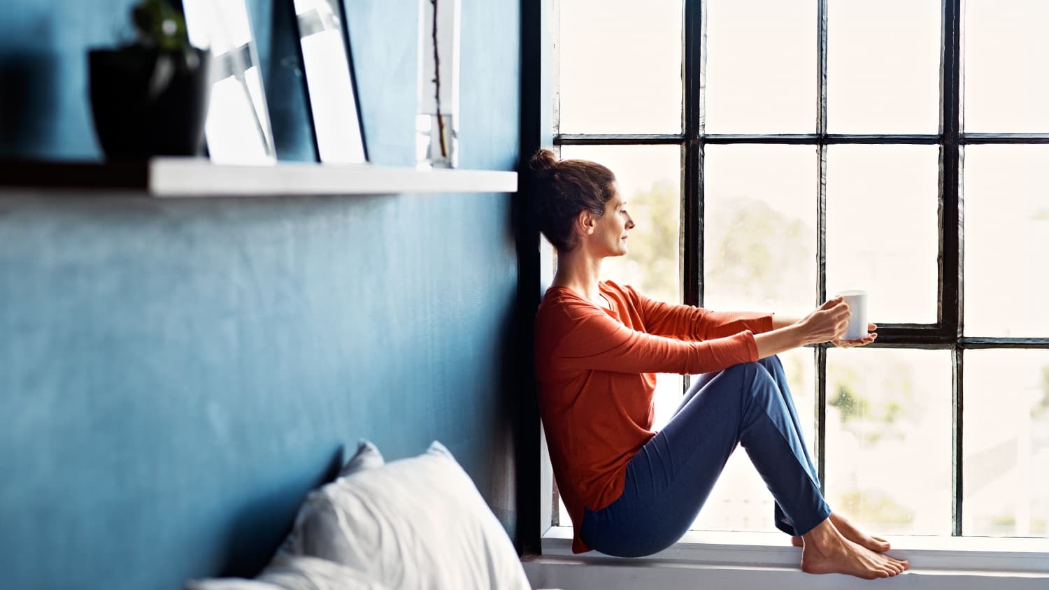 woman looking out a window after treatment for bone cancer