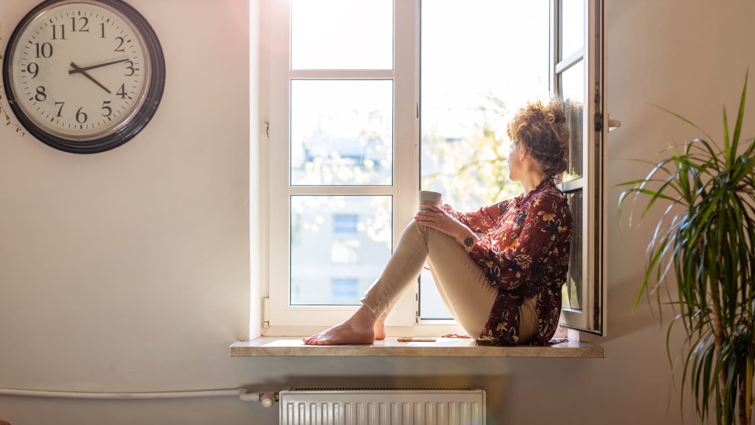 woman looking out window after coping with cancer side effects