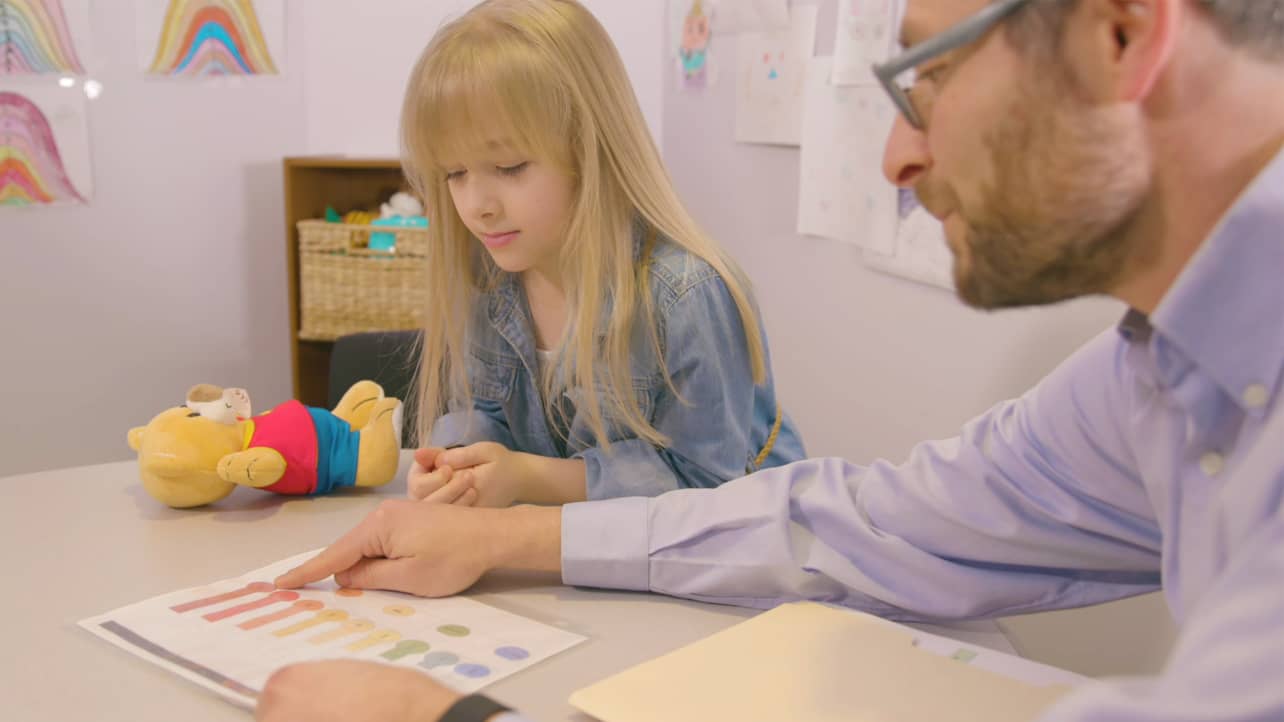 A doctor interacts with a child in a clinic setting.