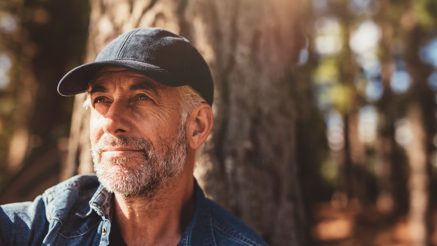 older man smiling in the woods after prostate cancer treatment