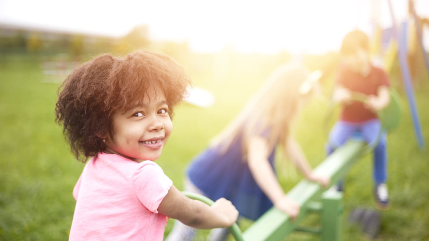 A girl with a bleeding disorder is outdoors playing.