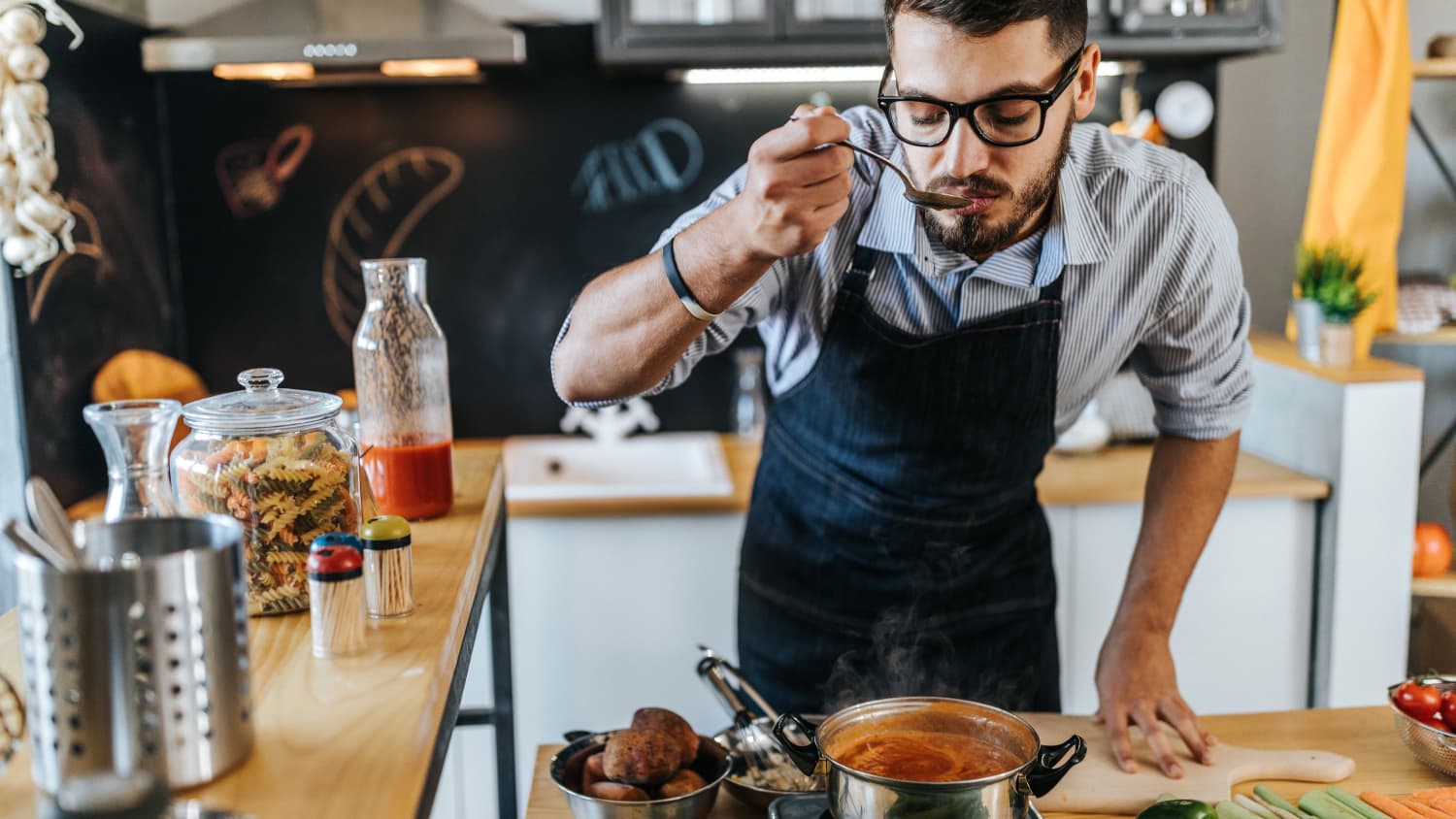 man cooking a meal, enjoying the renewed sense of taste and smell after recovering from COVID-19