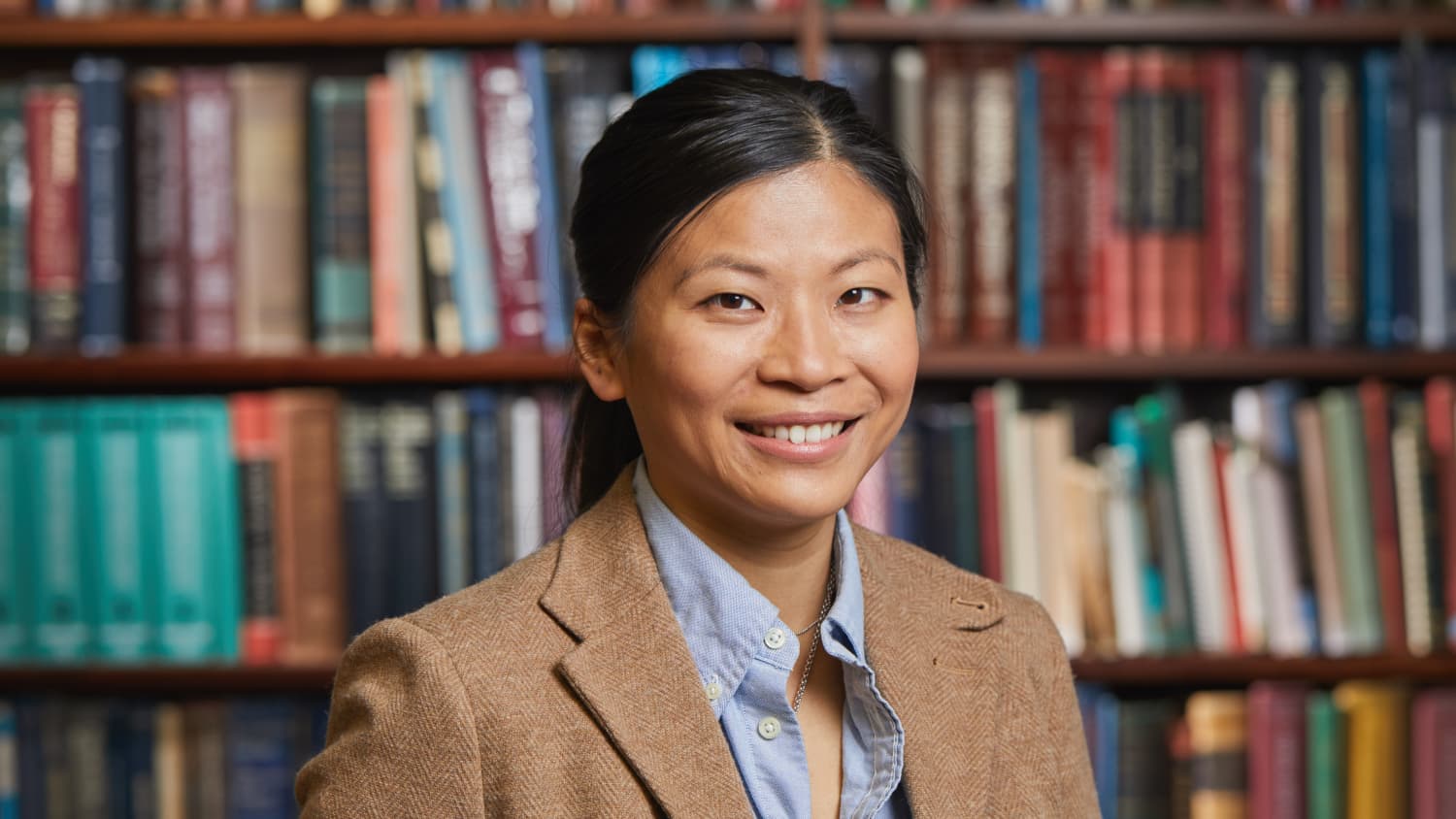 Dr. Yan Ho Lee stands in front of a bookcase in the otolaryngology office.