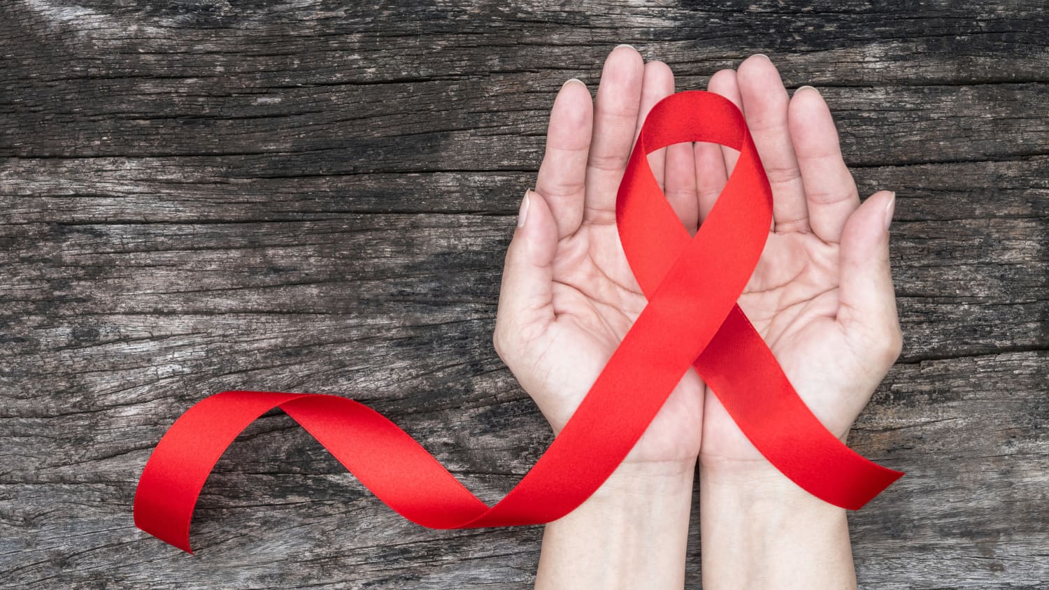 AIDS ribbon in an open hand