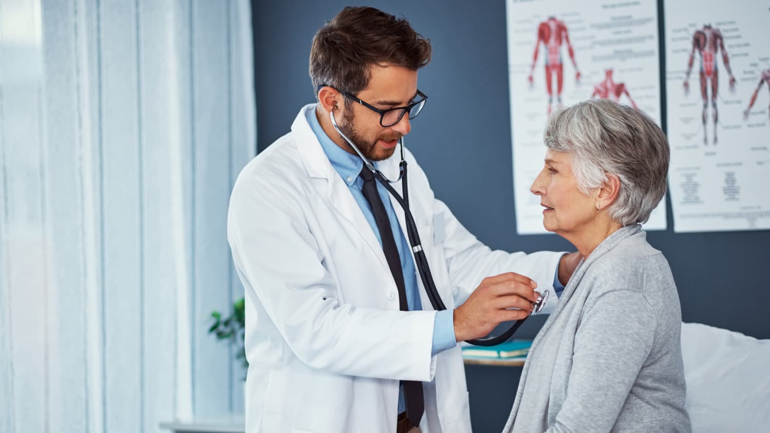 doctor applying a stethoscope to a patient's chest, listening to see if she needs a heart valve repair or replacement