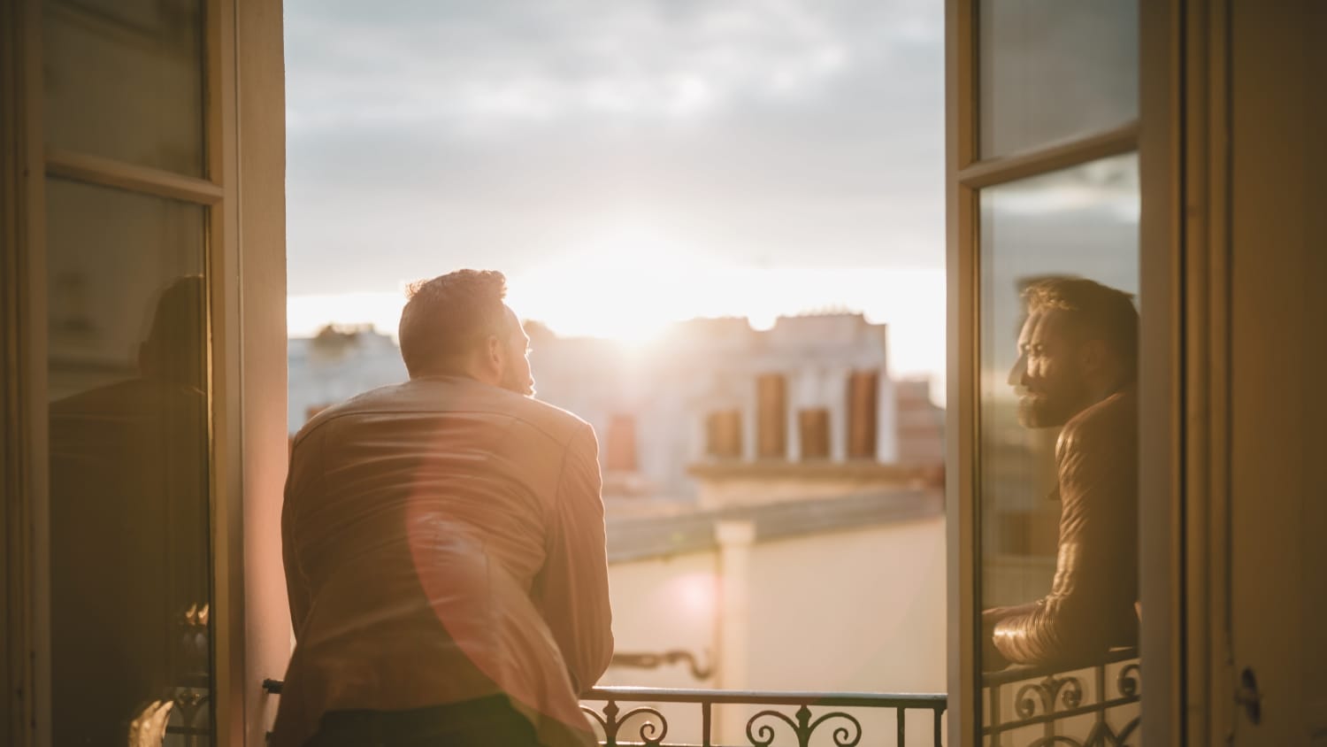 man looking out window after liver cancer diagnosis