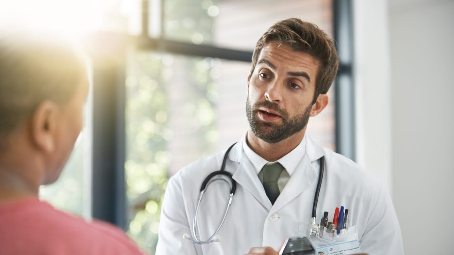 A doctors talks with a patient about radiation therapy with the Gamma Knife tool.