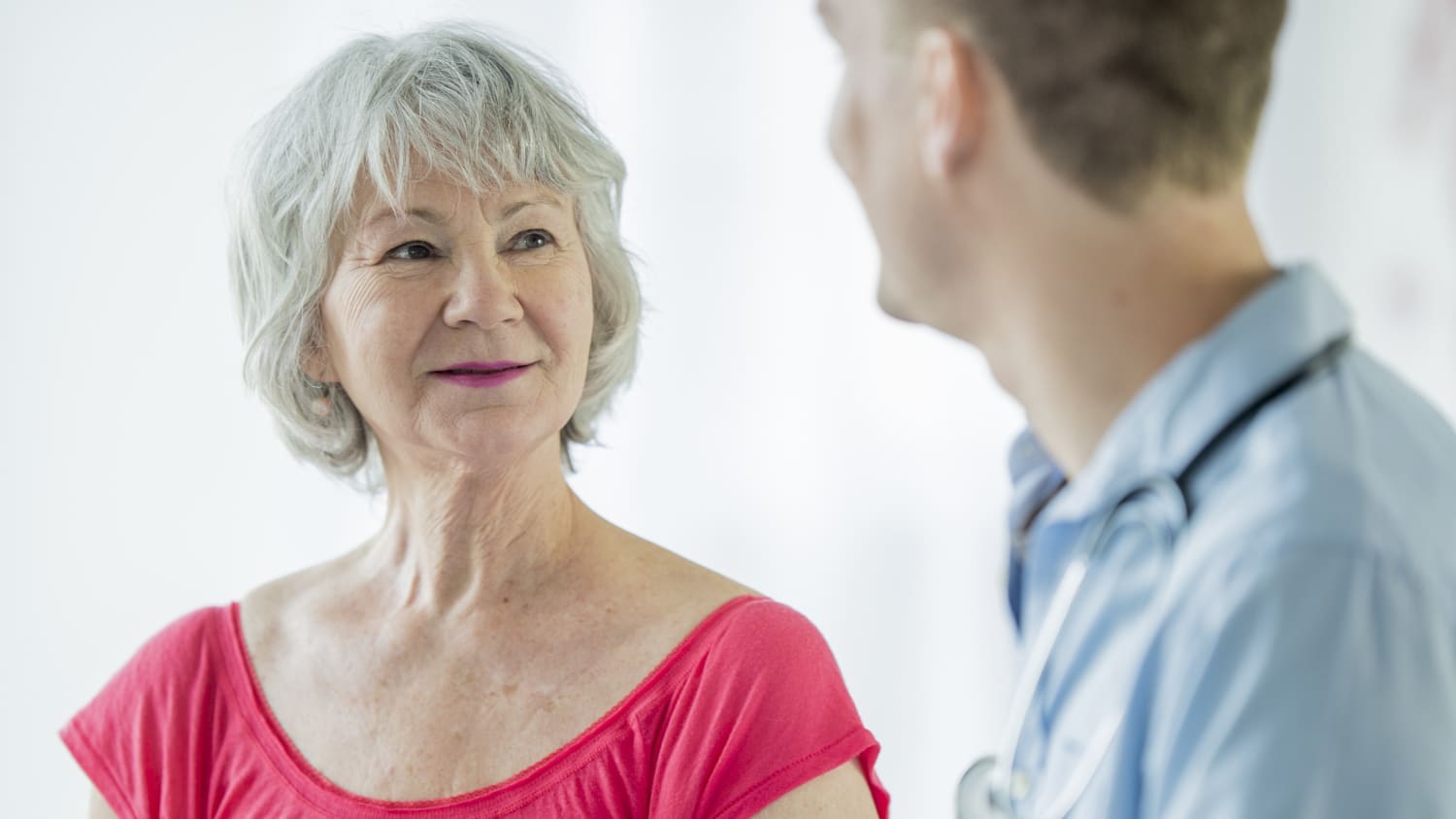 An older woman discusses the need for a tracheostomy with her doctor.