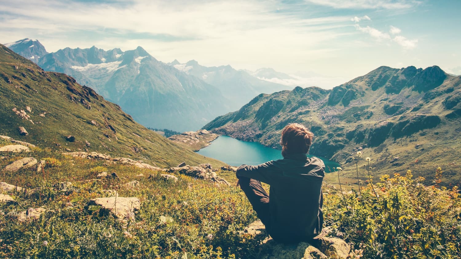 man sitting on hill, after coping with cancer-related fatigue