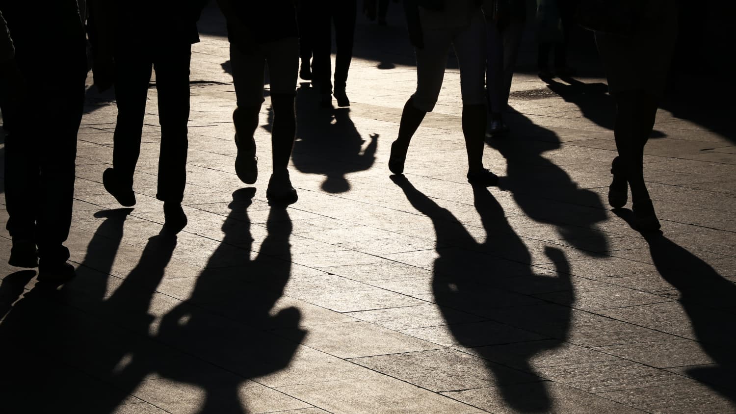 Shadows of people walking in streets, symbolizing the silent threat hepatitis C poses to millennials and baby boomers