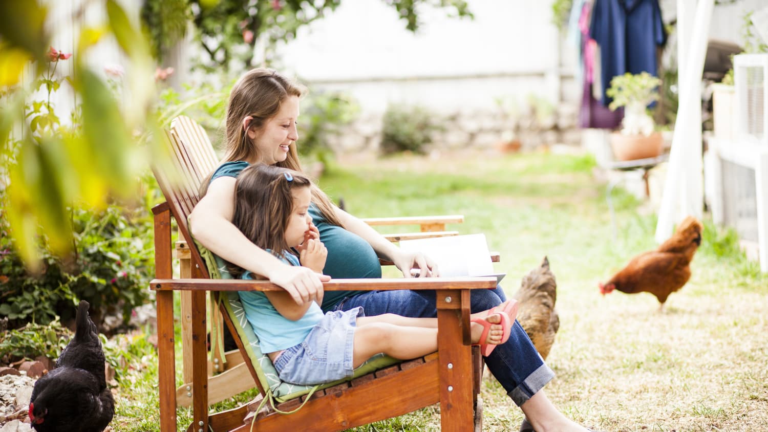 A pregnant woman who used prenatal screening and diagnosis sits with her older daughter.