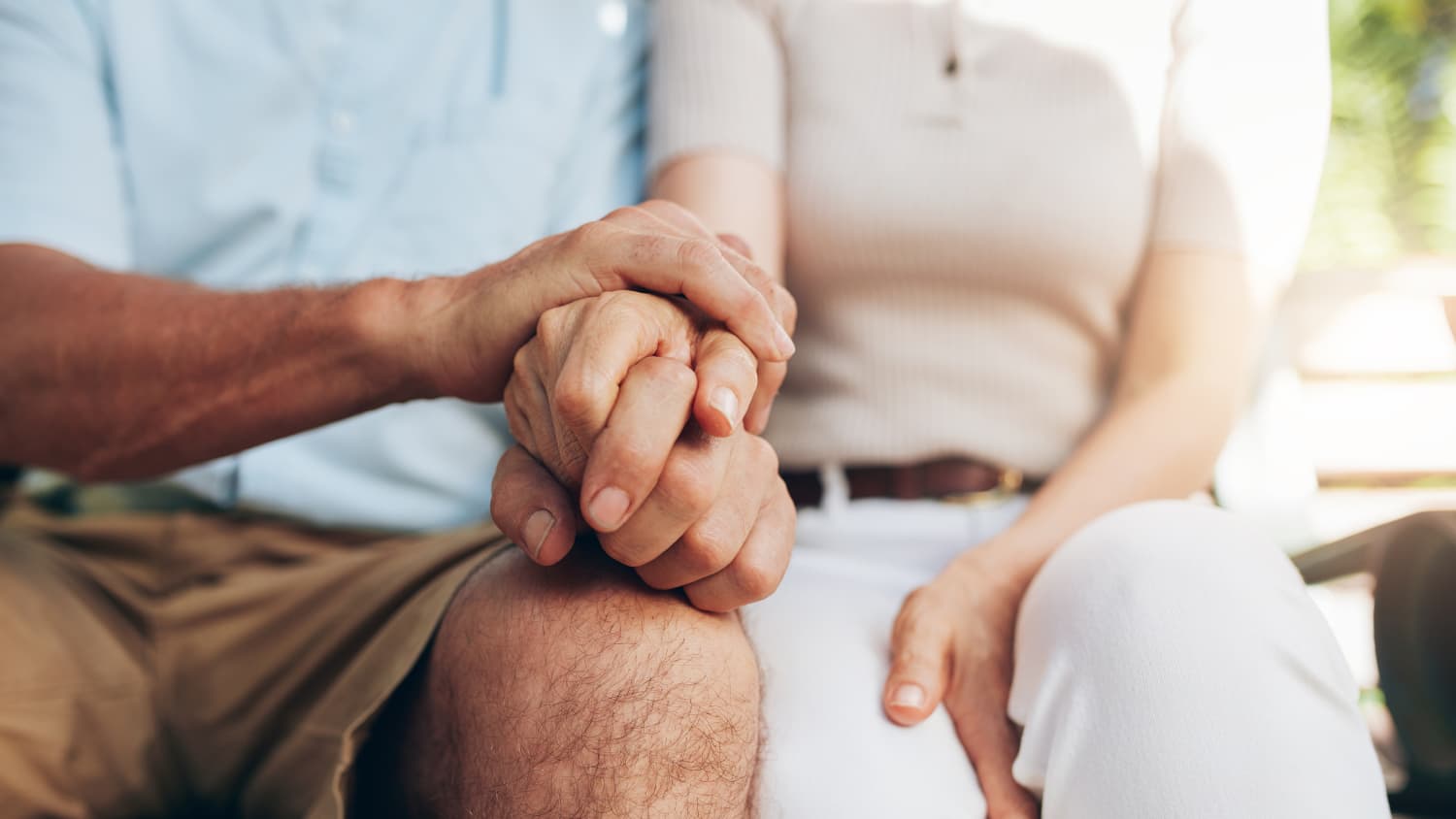 Husband holds his wife's hand after diagnosis of coronary artery disease