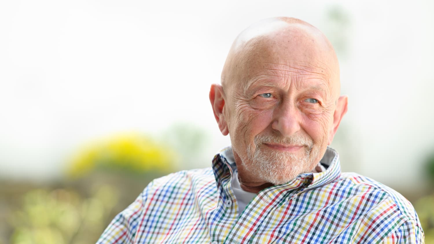 An older man who needs deep brain stimulation looks off in the distance.