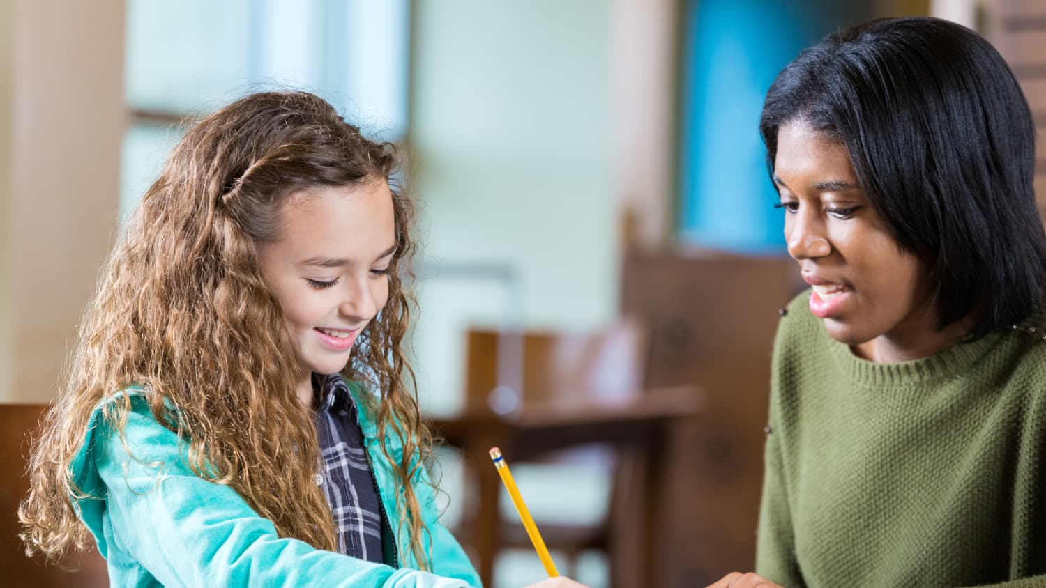 A teacher tutors a young girl who may have a learning disorder.