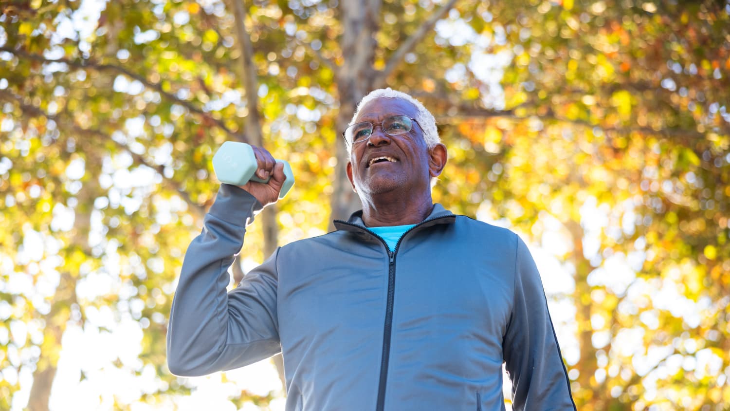 older man with Parkinson's disease lifting weights