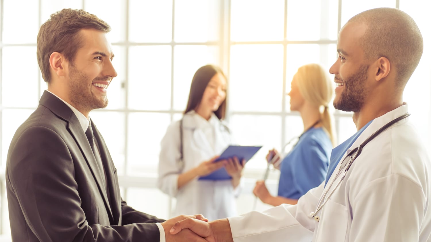 A volunteer for a clinical trial shakes a doctor's hand.