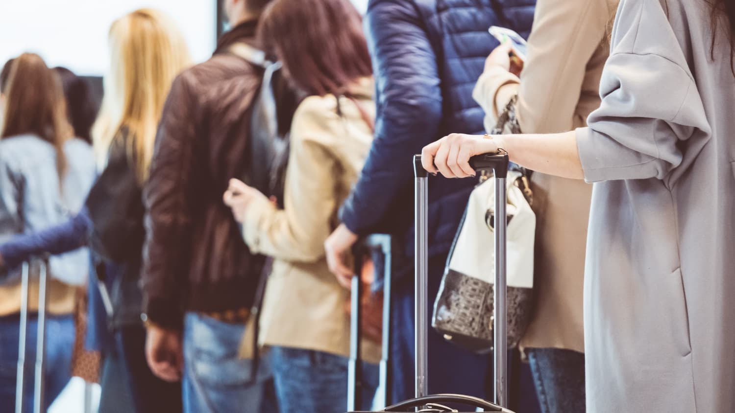 people standing in line at airport, worried about COVID-19 and Delta Plus