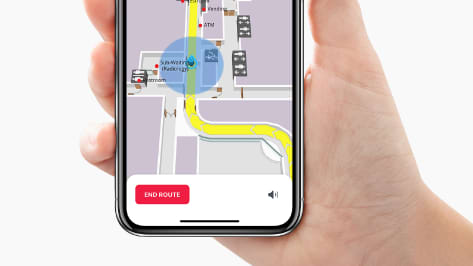 hand holding a smartphone displaying an app showing directions on a map