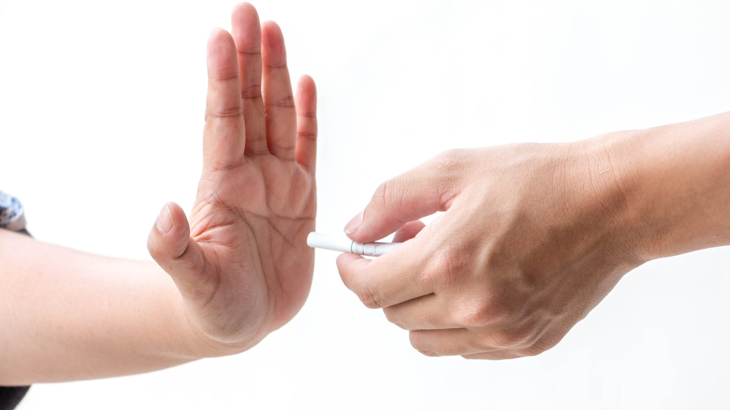 Close-up hand signal to refuse cigarette sent by one hand on white background, possibly signaling the need for a tobacco cessation program.