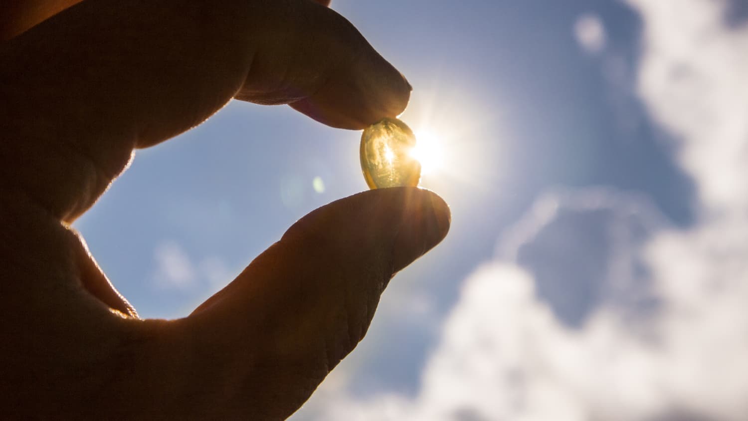 hand holding vitamin d supplement to help prevent vitamin d deficiency