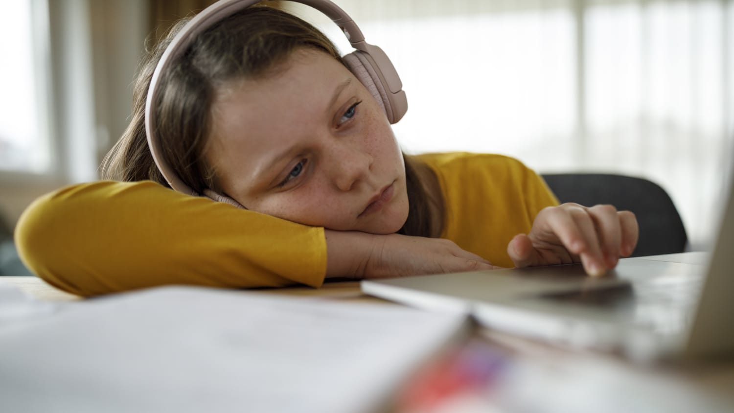 girl with head resting on her books, possibly from long COVID