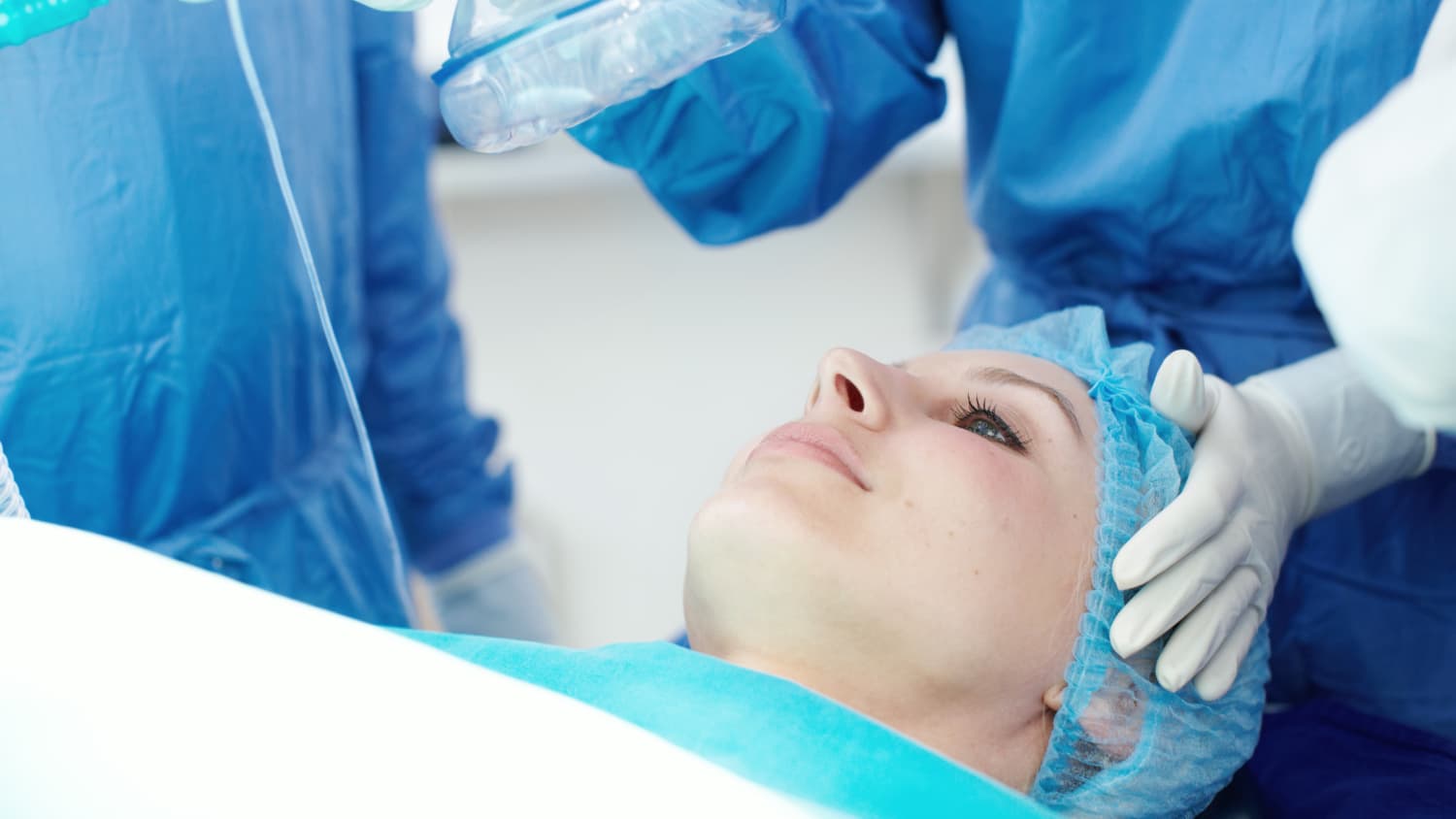 Doctors give general anesthesia to a woman on the operating table