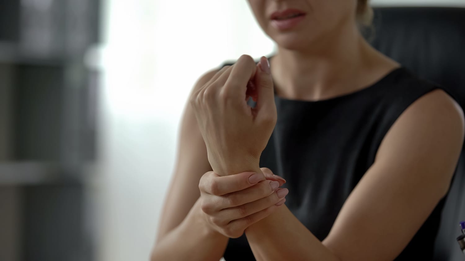 woman with wrist pain, possibly from a ganglion cyst