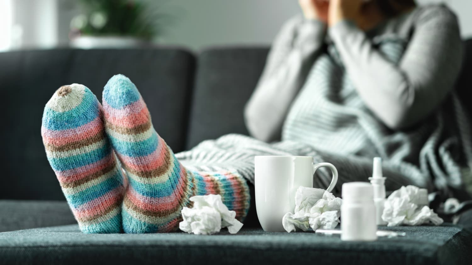 person on the couch sick with cold, flu, or covid-19