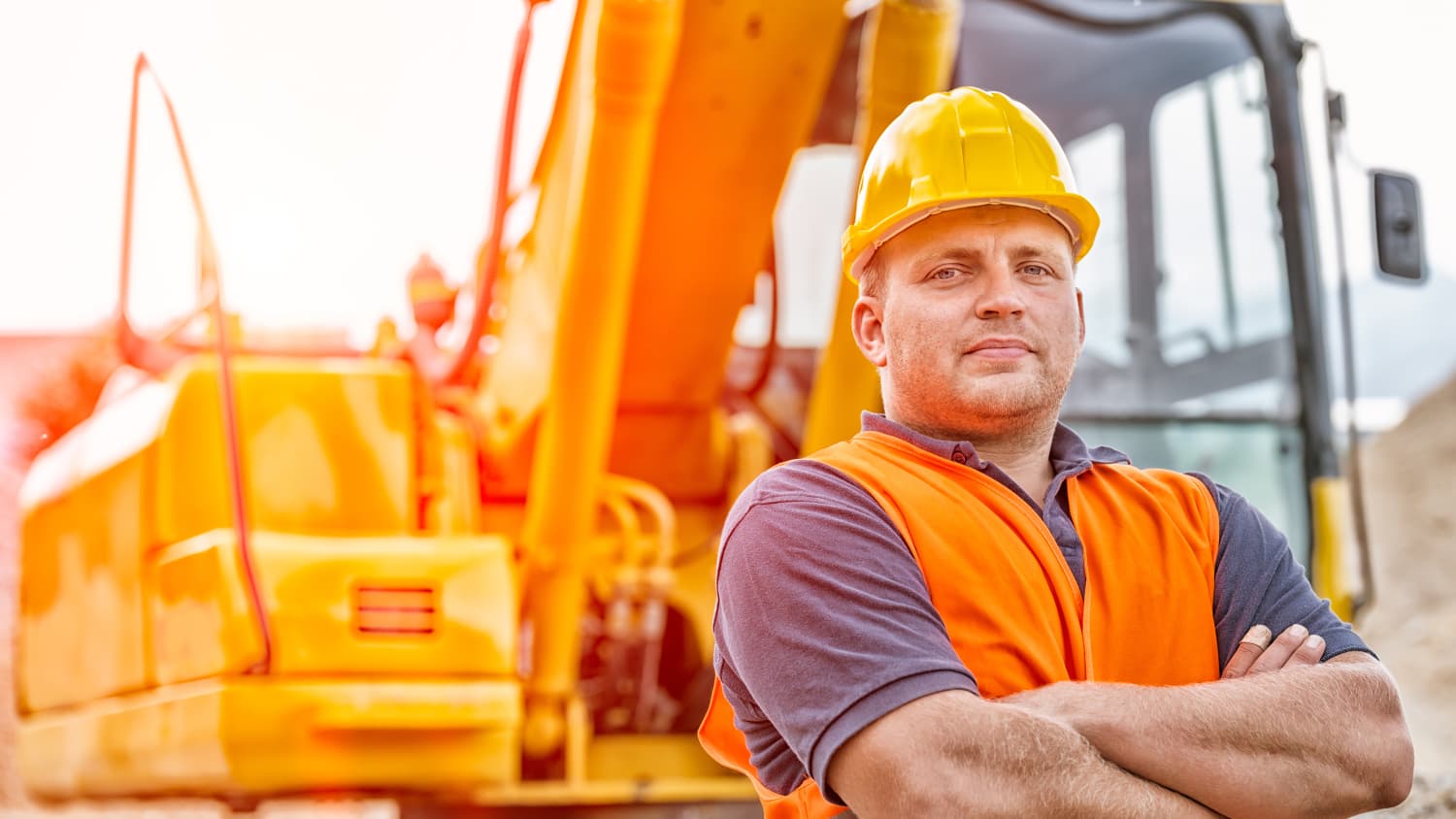 A construction worker who suffers from sleep apnea stands near his vehicle with his arms folded