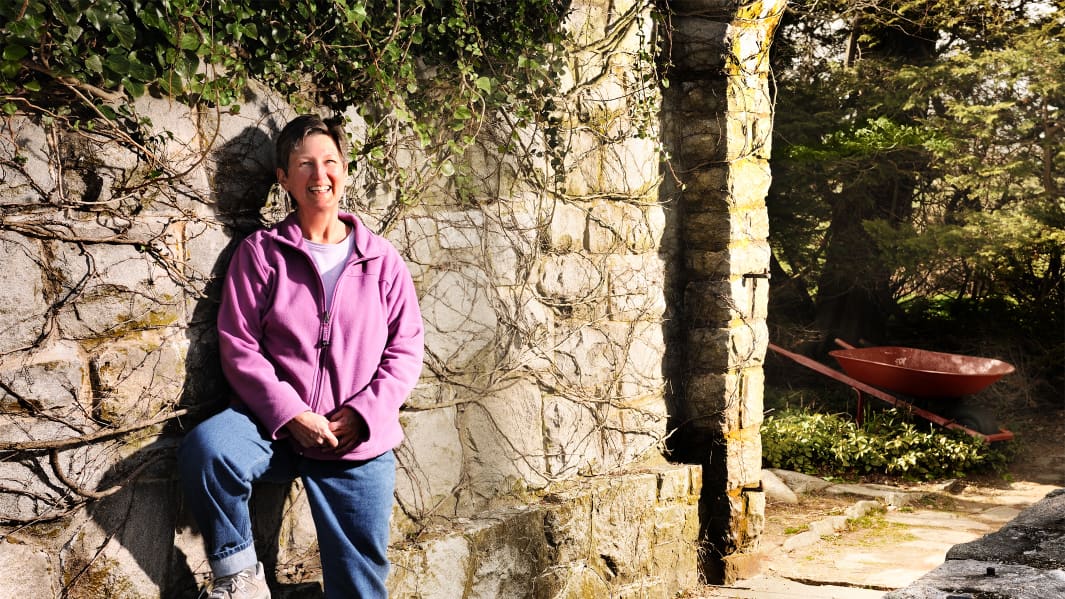 woman standing infront of stone wall