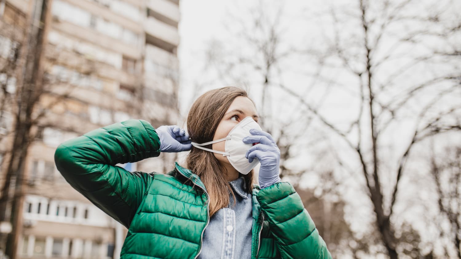 woman putting a mask on to protect against COVID-19 from the lastest coronavirus strain BA.2.86 (Pirola)