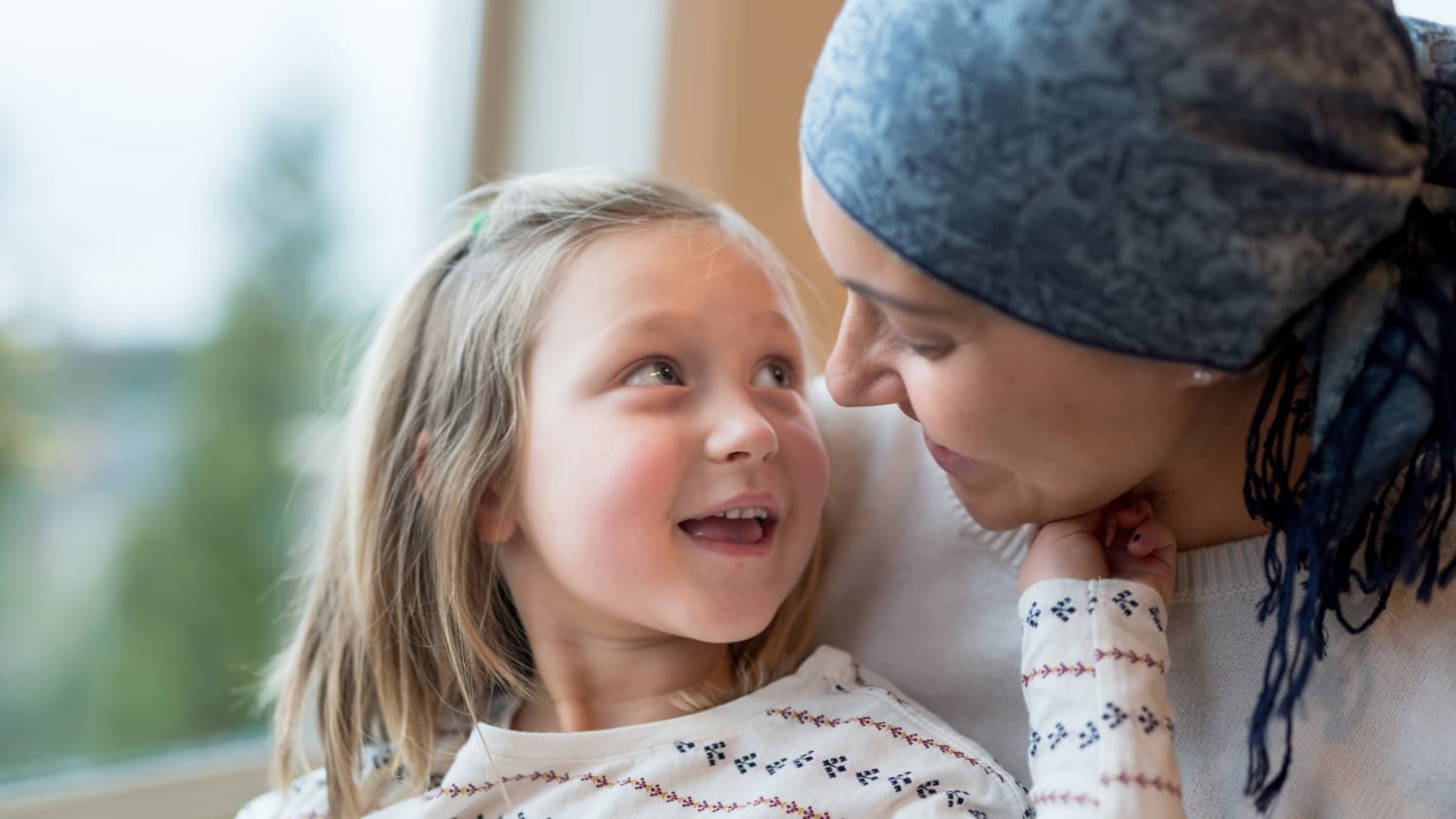 woman, possibly undergoing treatment for inflammatory breast cancer, and her child hugging