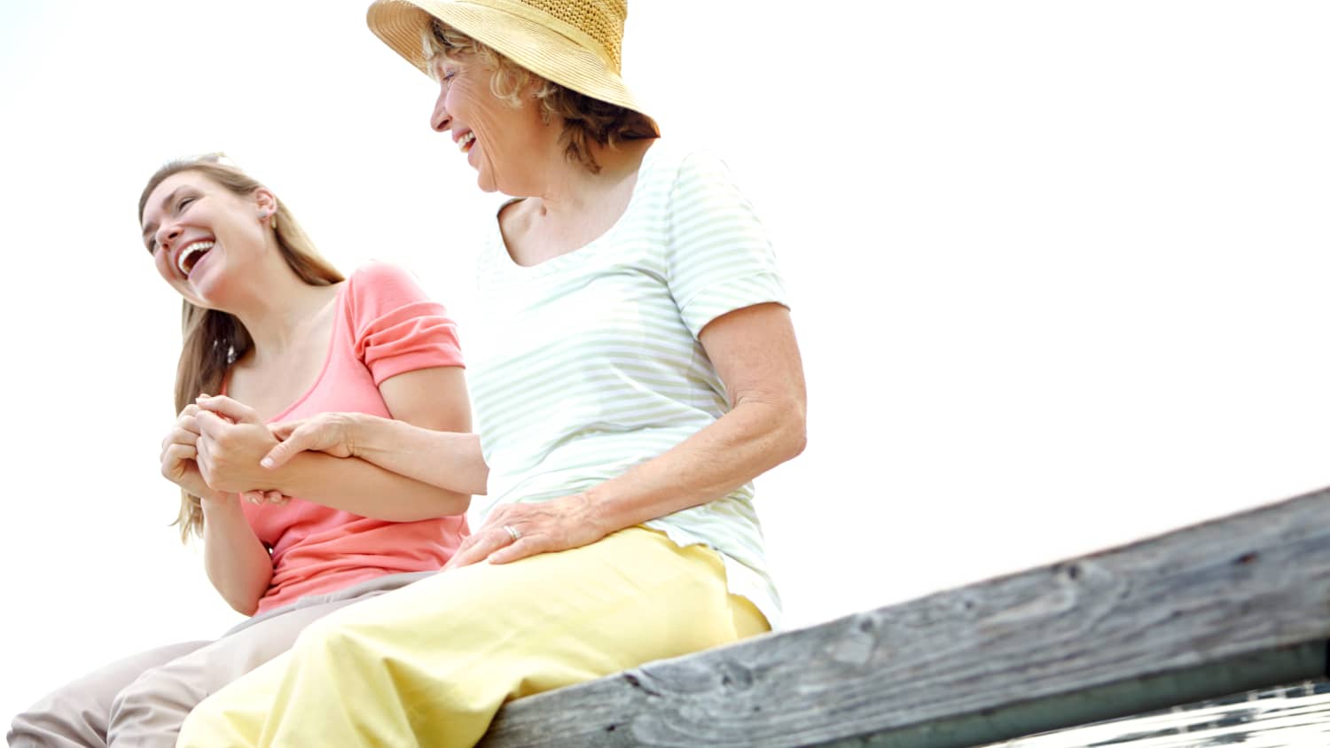 A mother and daughter laughing at the lake.