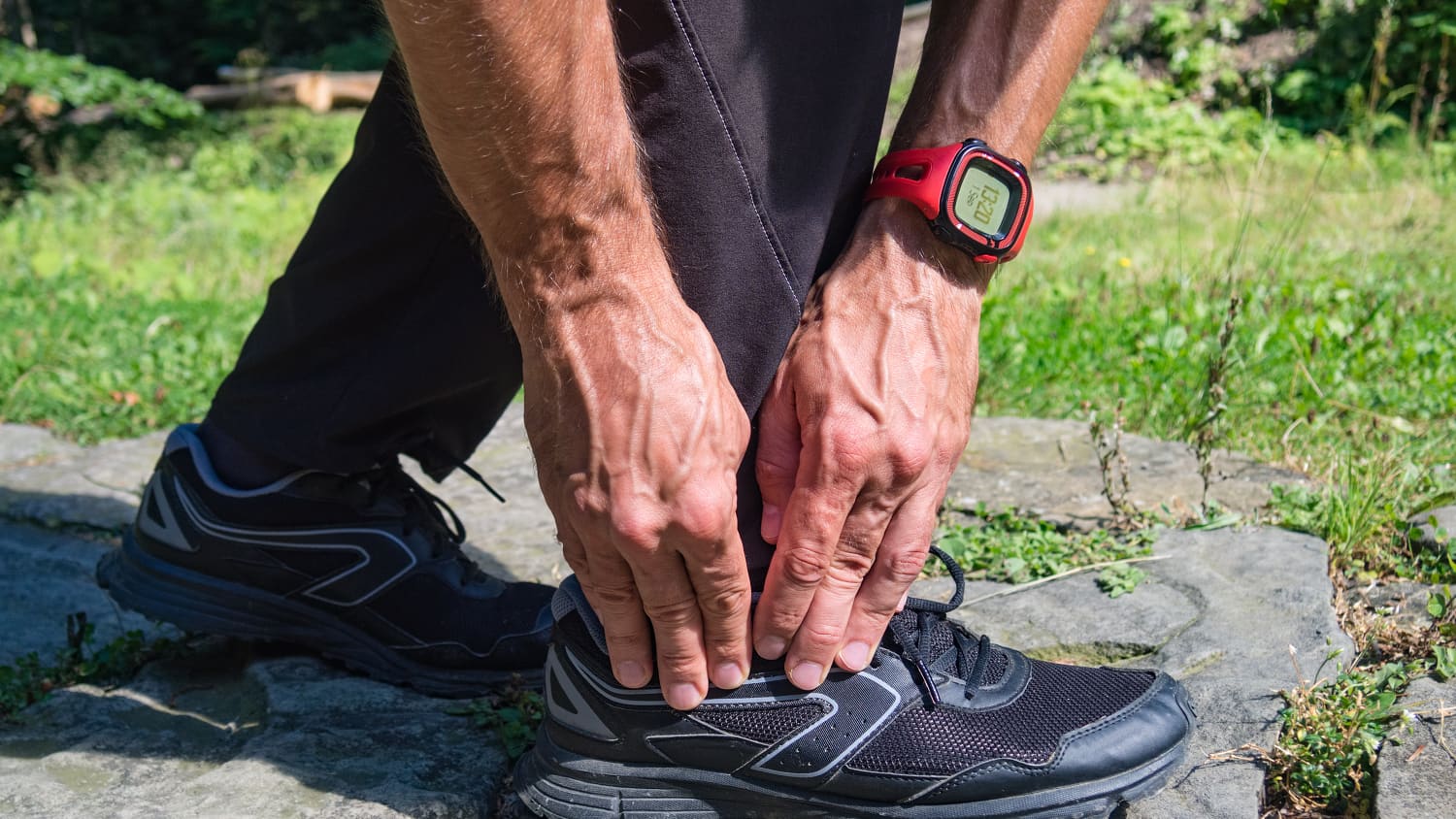 A man, who possibly needs total ankle replacement, touches the side of his foot