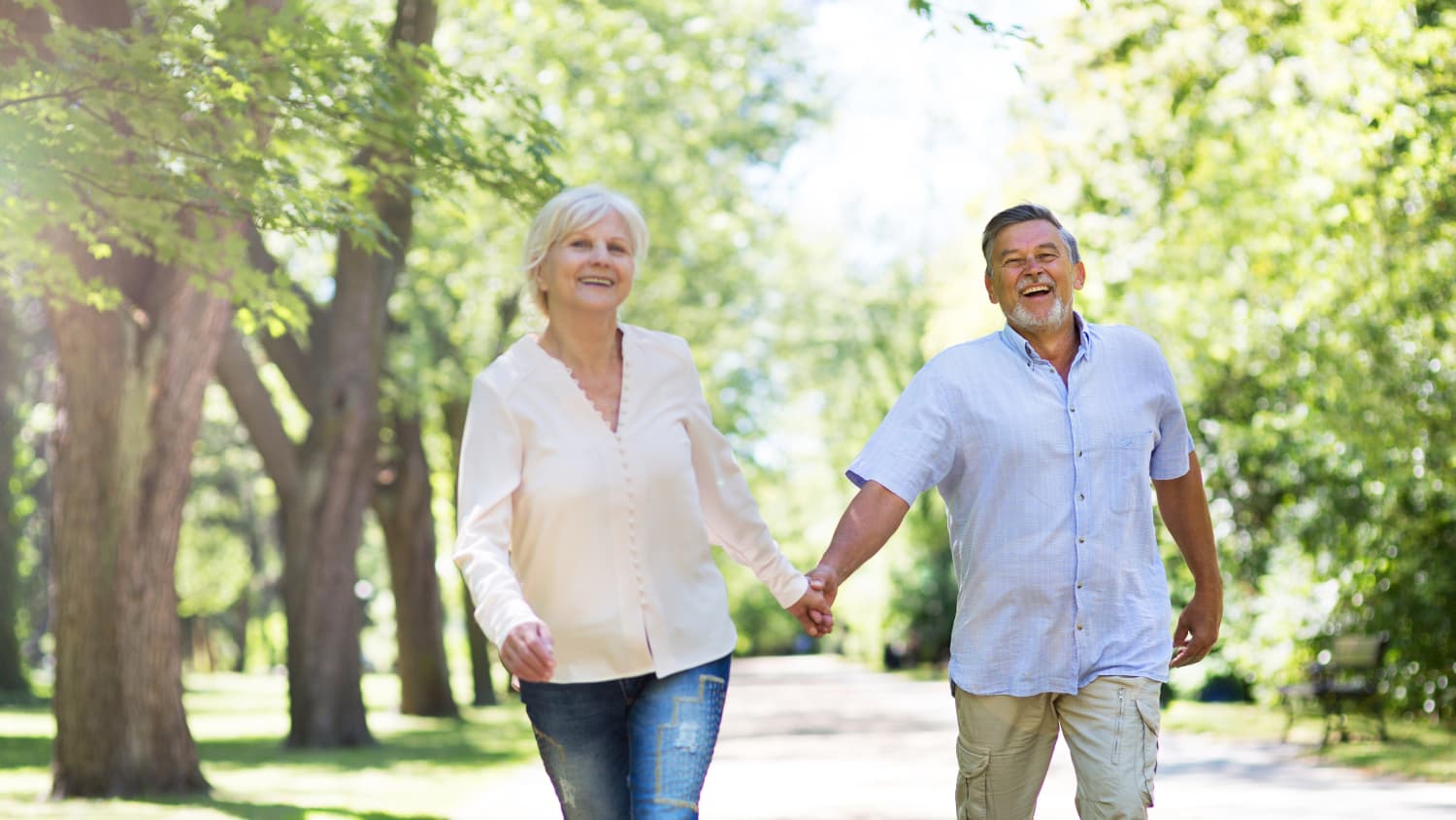 A senior couple walks outside wearing sunscreen to avoid melanoma.