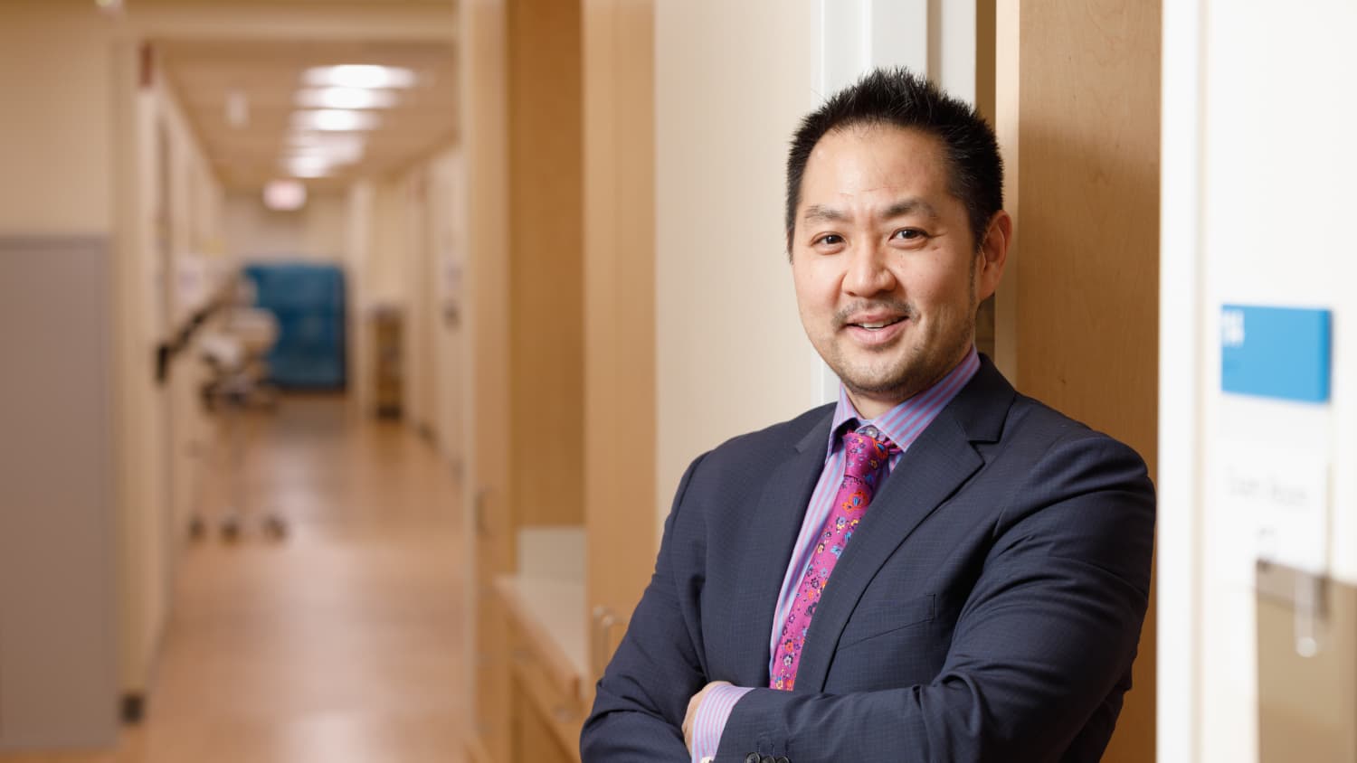 A doctor who treats cervical radiculopathy stands in a hallway.