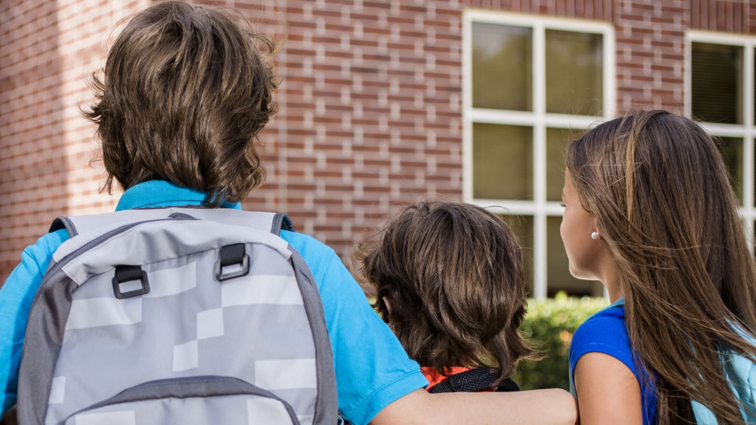 Two older children guide a younger child who has been refusing to go to school.