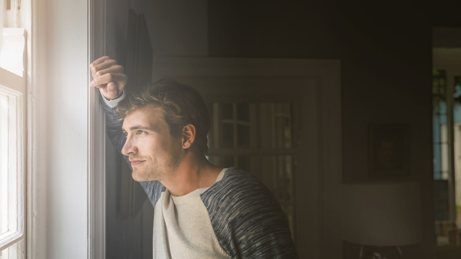 man looking out the window, perhaps thinking of a throat cancer diagnosis